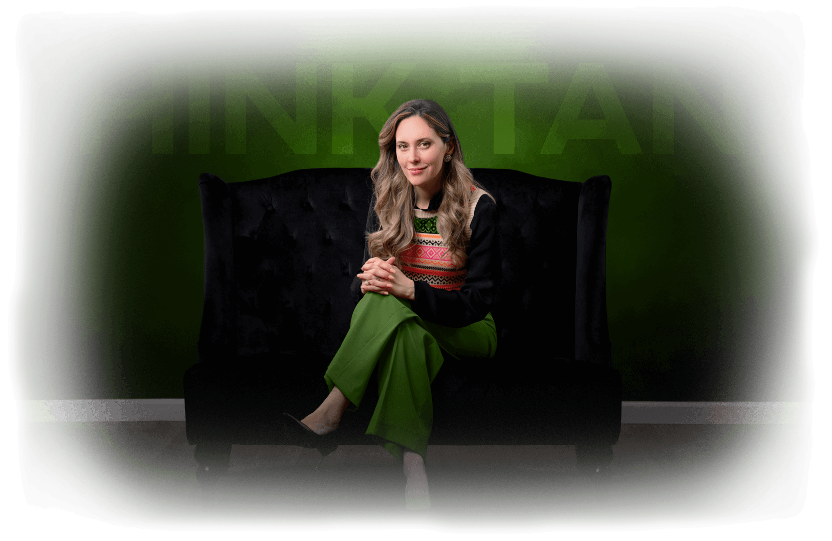 The Coaching Business Think Tank • Allexis Tuccio, MCC, SP EMCC, ACTC, seated on a dark sofa, looking at the camera, with a subtle green glow behind her on a transparent background.